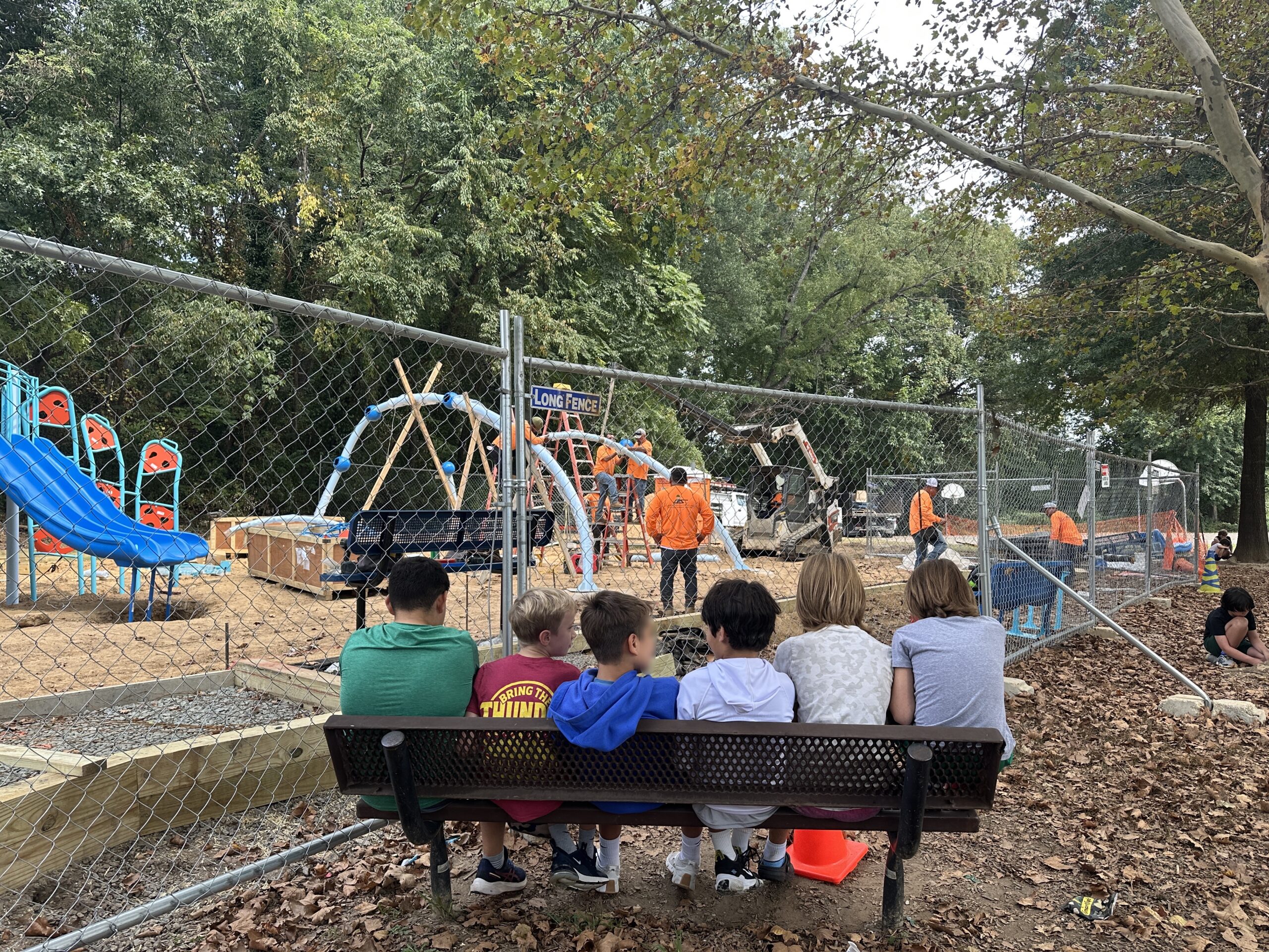 students watch as the playground gets built